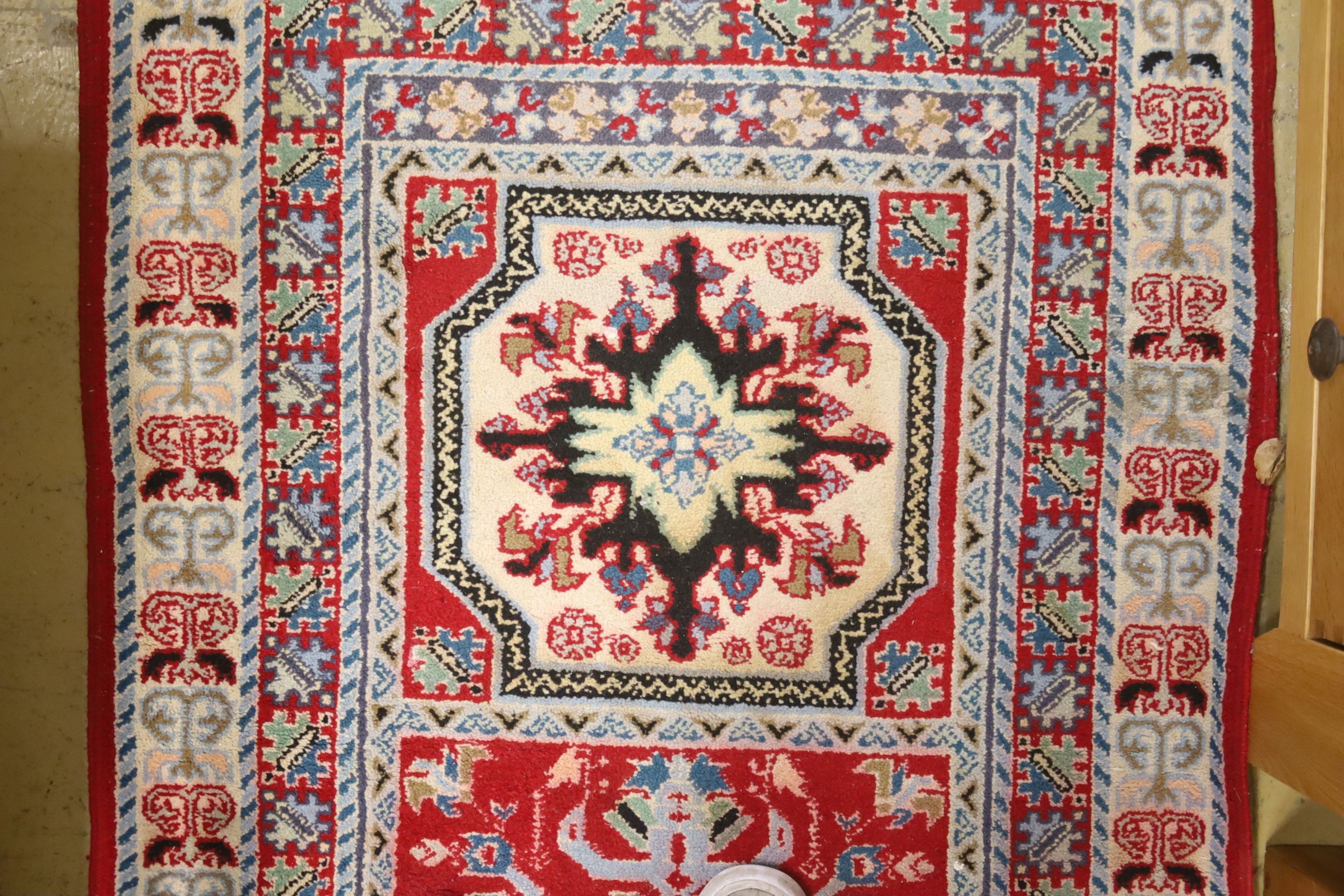 A Kazak style ivory ground rug, 144 x 64cm